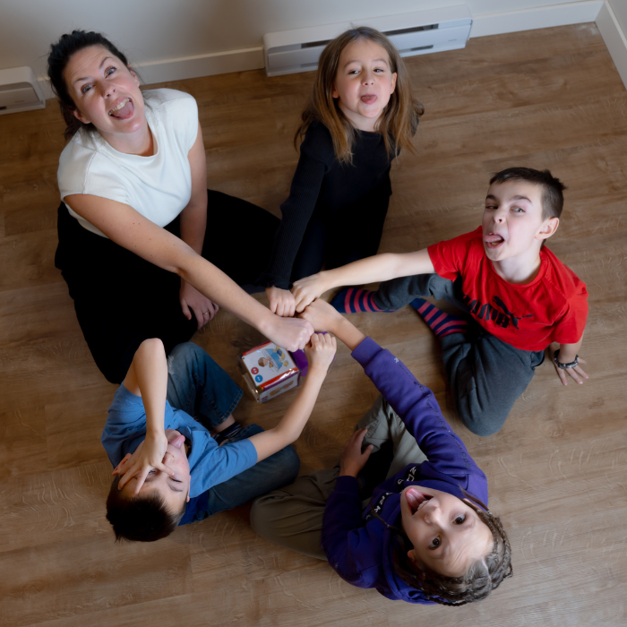 Gabrielle, orthopédagogue et fondatrice du Centre multidisciplinaire Gabrielle, animant une séance d'école maison avec des enfants jouant à un jeu éducatif.