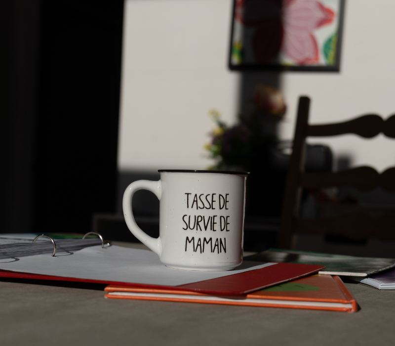 Image d'une tasse "Tasse de survie de maman" sur un bureau pour représenter le service du centre : accompagnement parental.